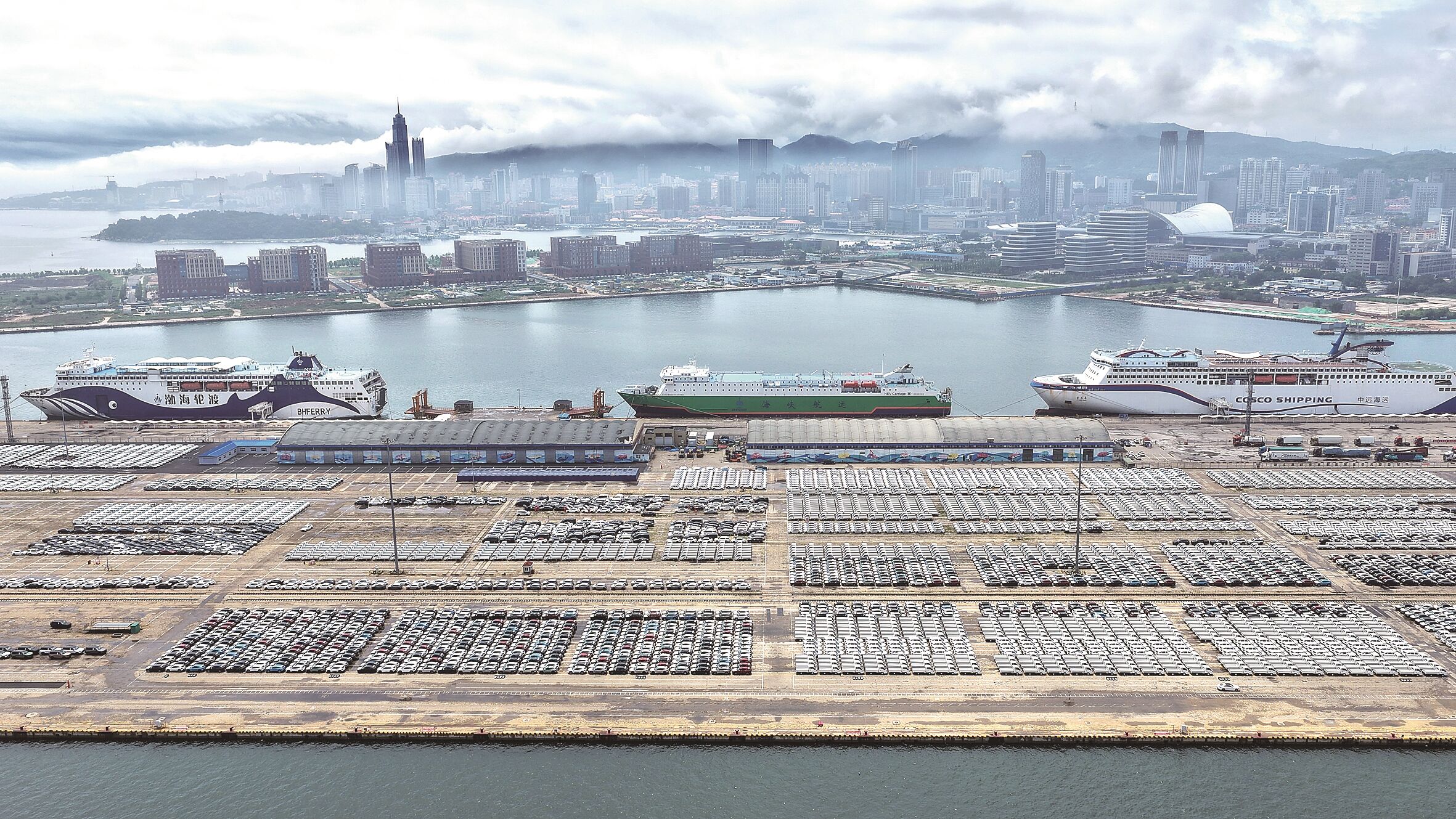 7月14日,大批国产汽车在山东港口烟台港等待装船出口(无人机照片)。唐克 摄