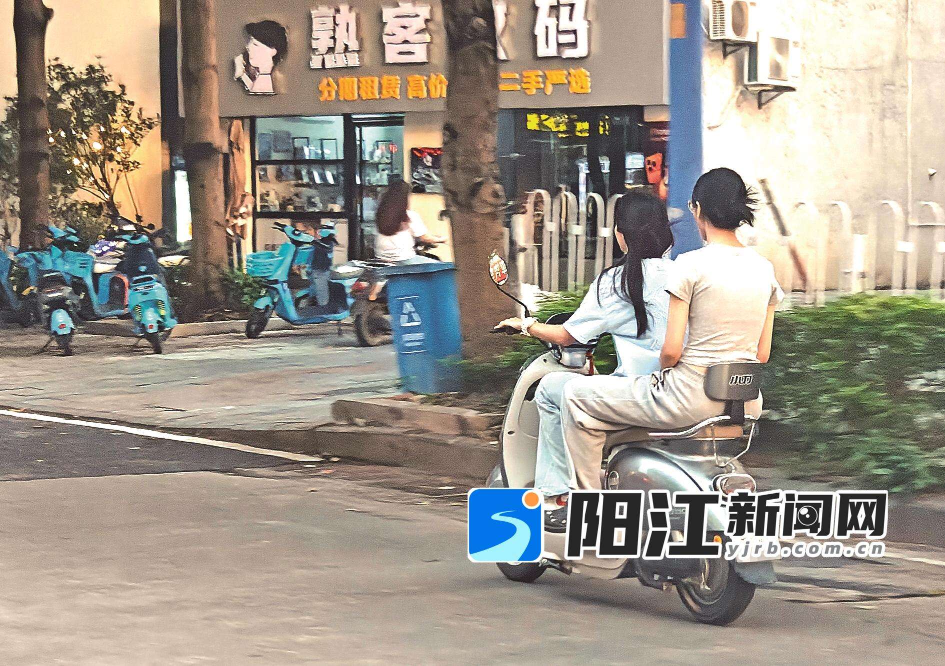 街头不时可见未戴安全头盔的青少年骑着电动车穿行在街头巷尾。 梁文栋 摄