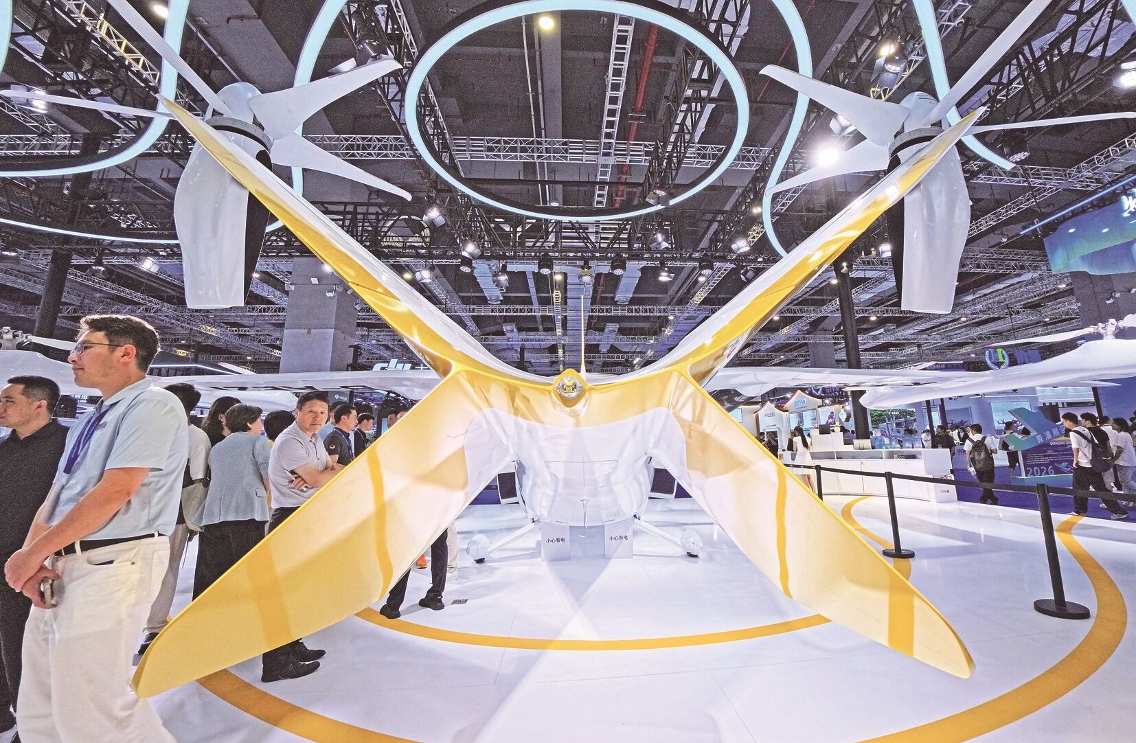 参观者在沃飞长空公司展台一架AE200系列电动垂直起降飞行器旁参观。方喆 摄