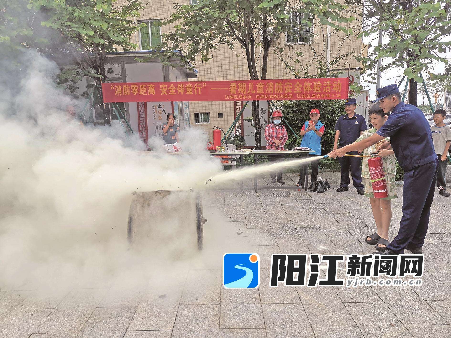 消防员手把手教孩子使用灭火器。 受访单位 供图