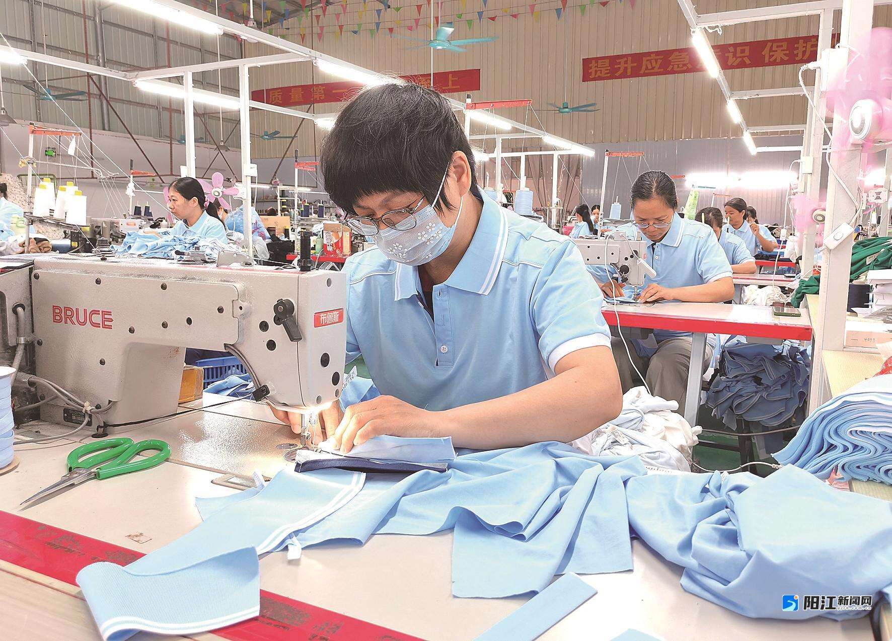 阳春市三人行服饰有限公司,工作人员在生产新款中小学校服。谭文强 摄