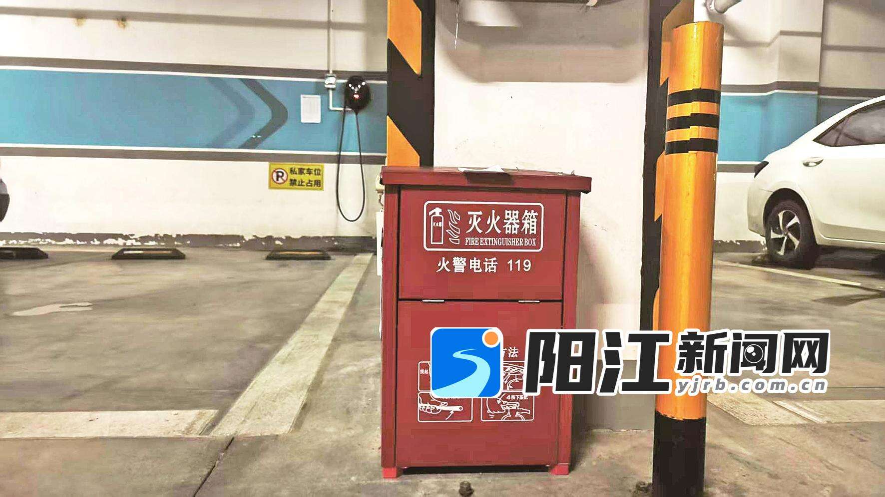 万山香悦四季小区地下车库配备的灭火器箱,后方墙面可见业主安装的电车充电桩。