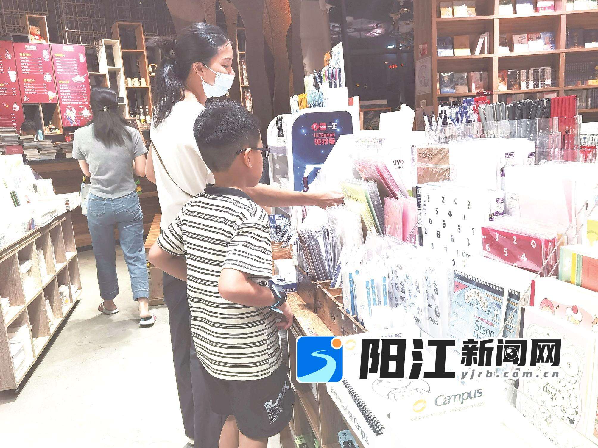 家长和孩子一同在书店文具区挑选开学文具用品。刘昭融 摄