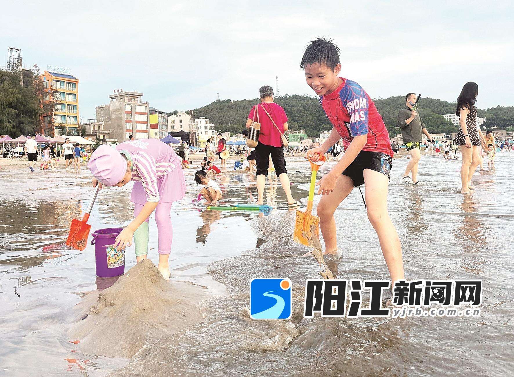 小朋友们在珍珠湾堆沙戏水游玩。
