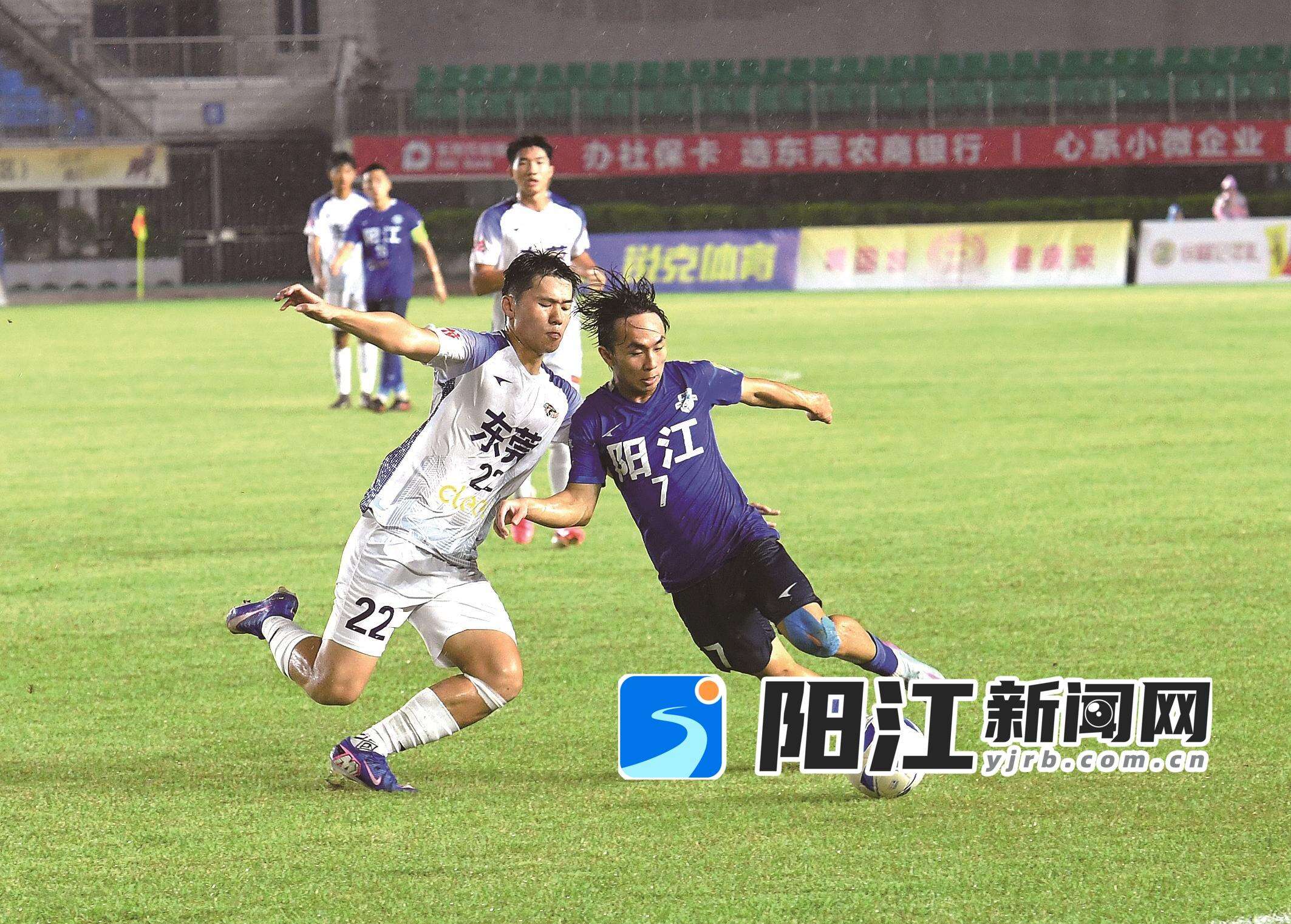 双方球员在雨中积极拼抢。谭文强 摄