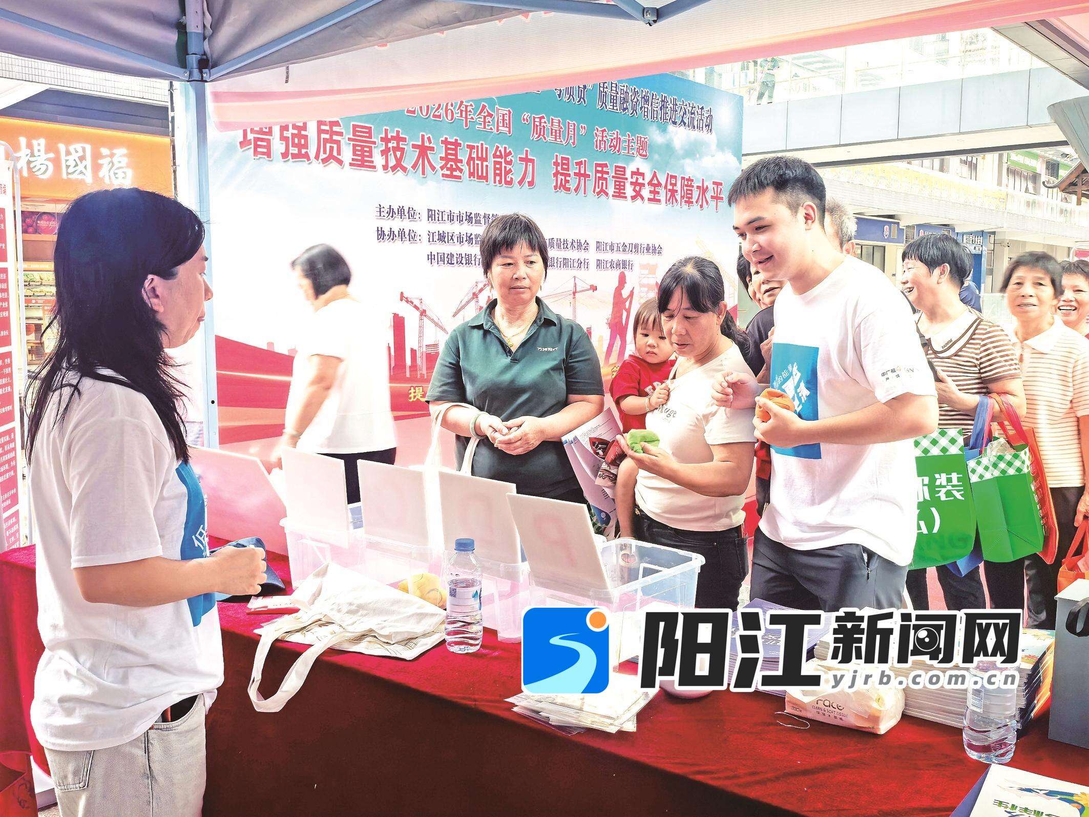 工作人员向群众宣传相关政策法规,并赠送小礼品。邓惠心 摄