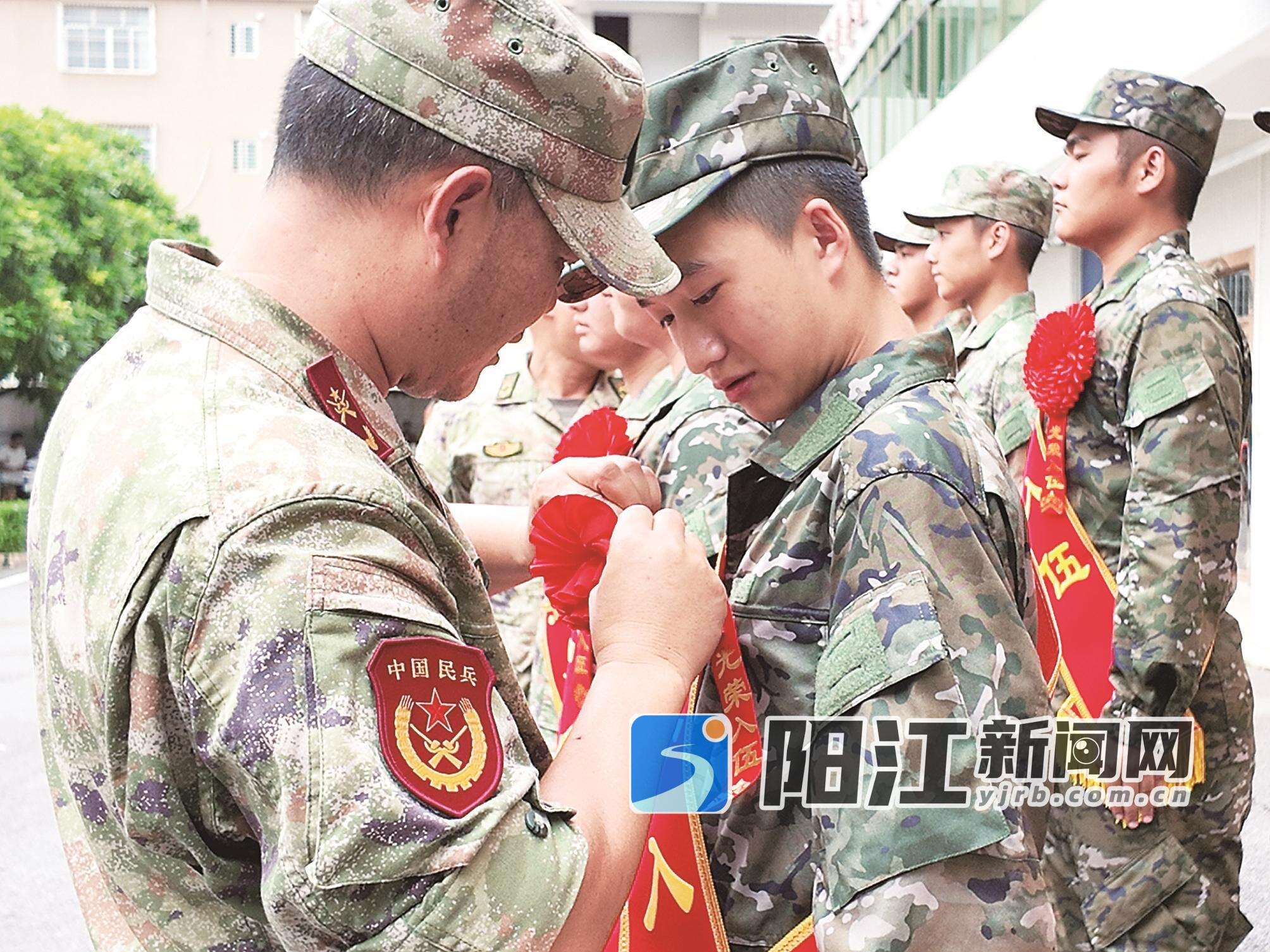 阳西县人武部征兵工作人员给新兵佩戴大红花。 受访单位供图