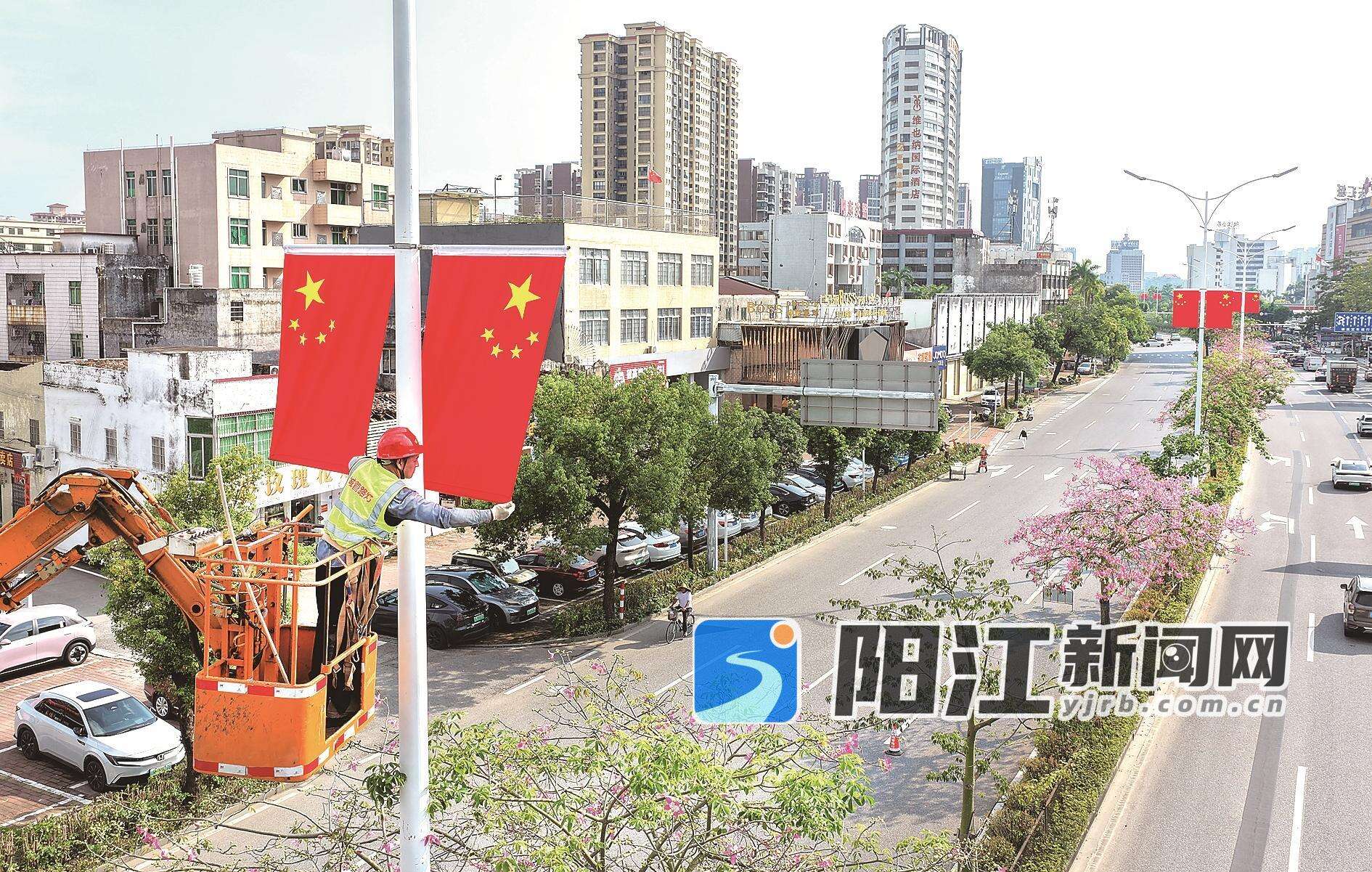 工作人员在市区东风三路悬挂国旗。梁文栋 摄