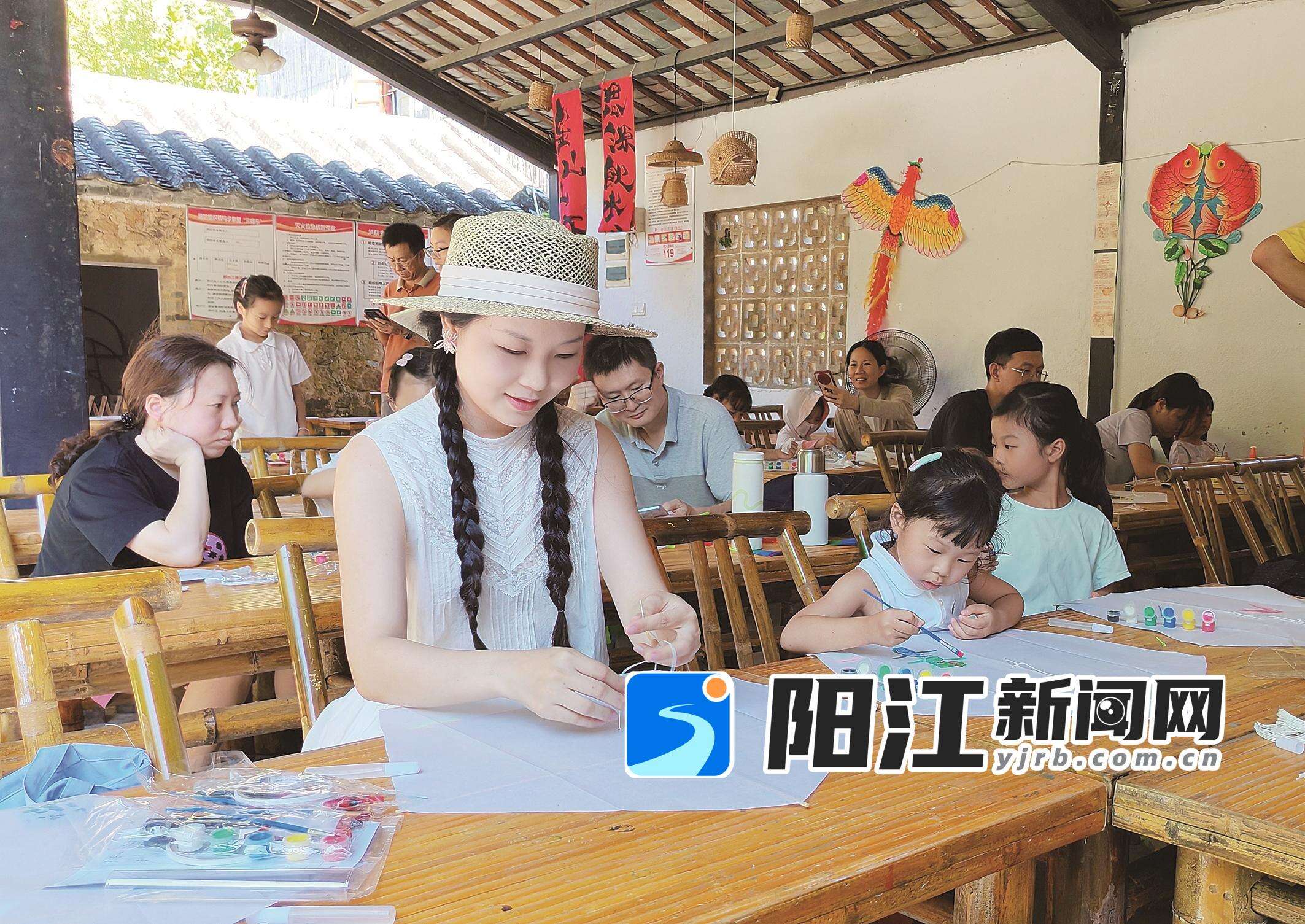 游客在“非遗学堂”里学习制作传统风筝。谭文强 摄