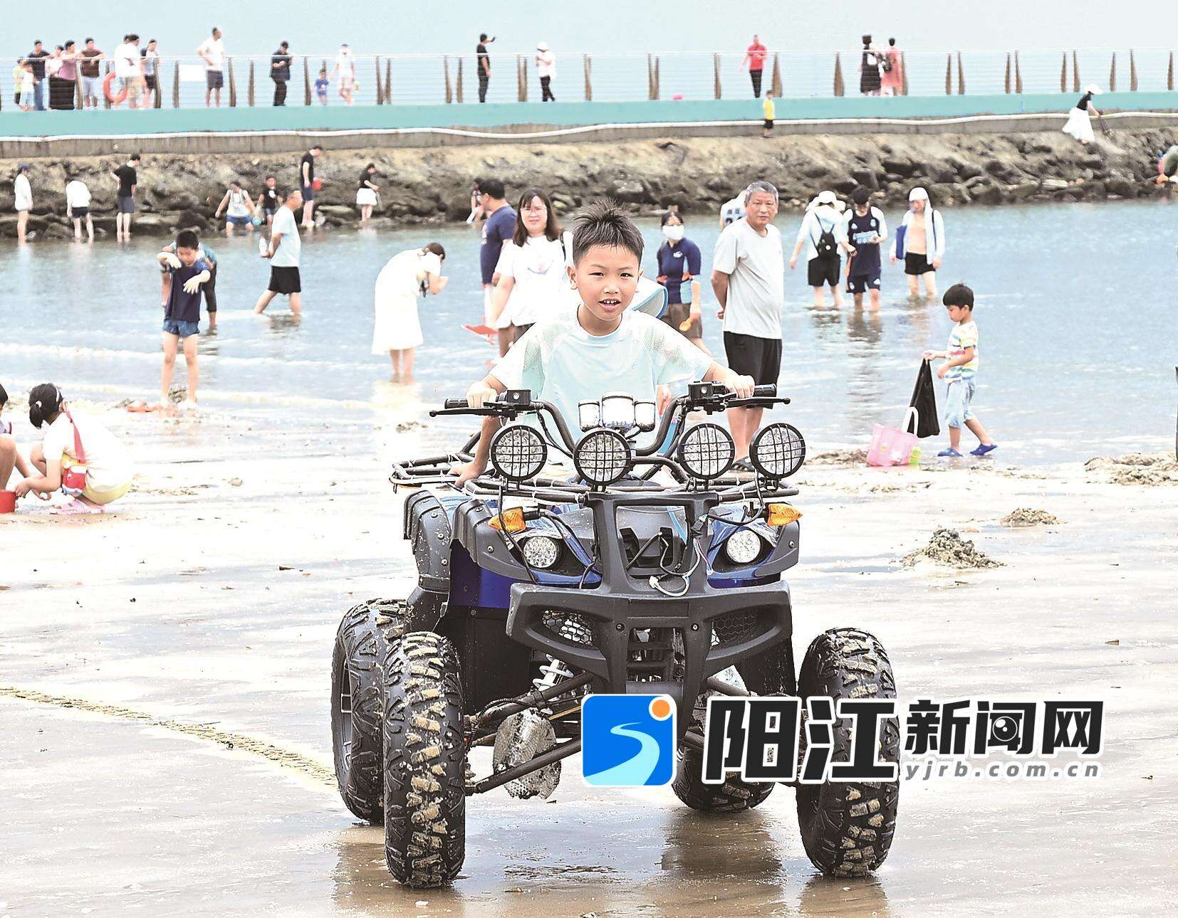 东平镇沙滩上,小朋友开心地体验四轮沙滩车。