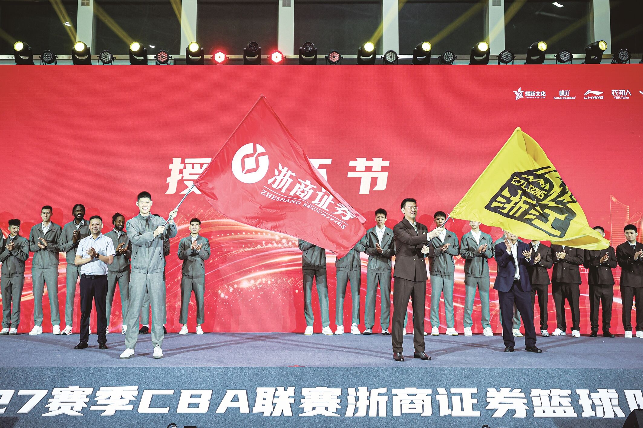 10月12日,浙江浙商证券队球员胡金秋(前左)和主教练王博(前右)在出征仪式上挥舞球队旗帜。 新华社发